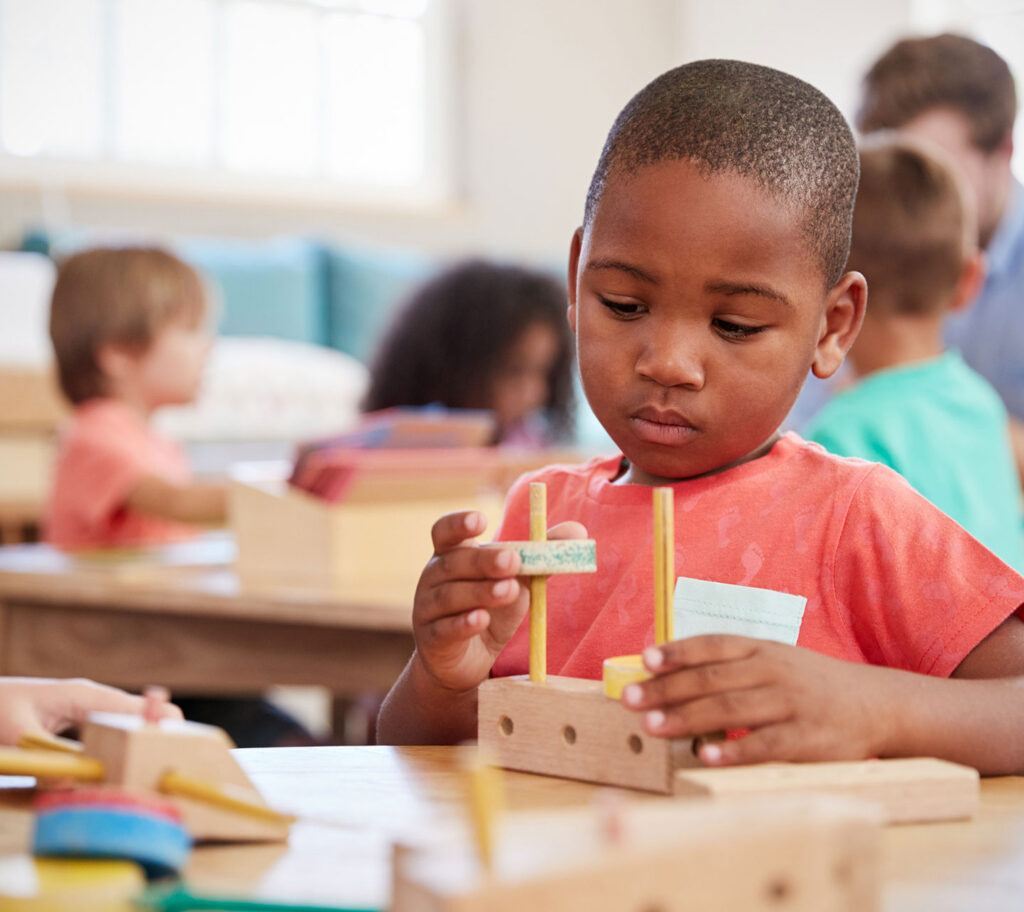 child uses wooden construction toys